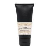 Black tube of amber hand cream on a white background